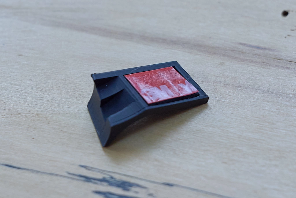 Photo of a thumb grip intended for a Leica SL2 camera with VHB tabpe visible on the back