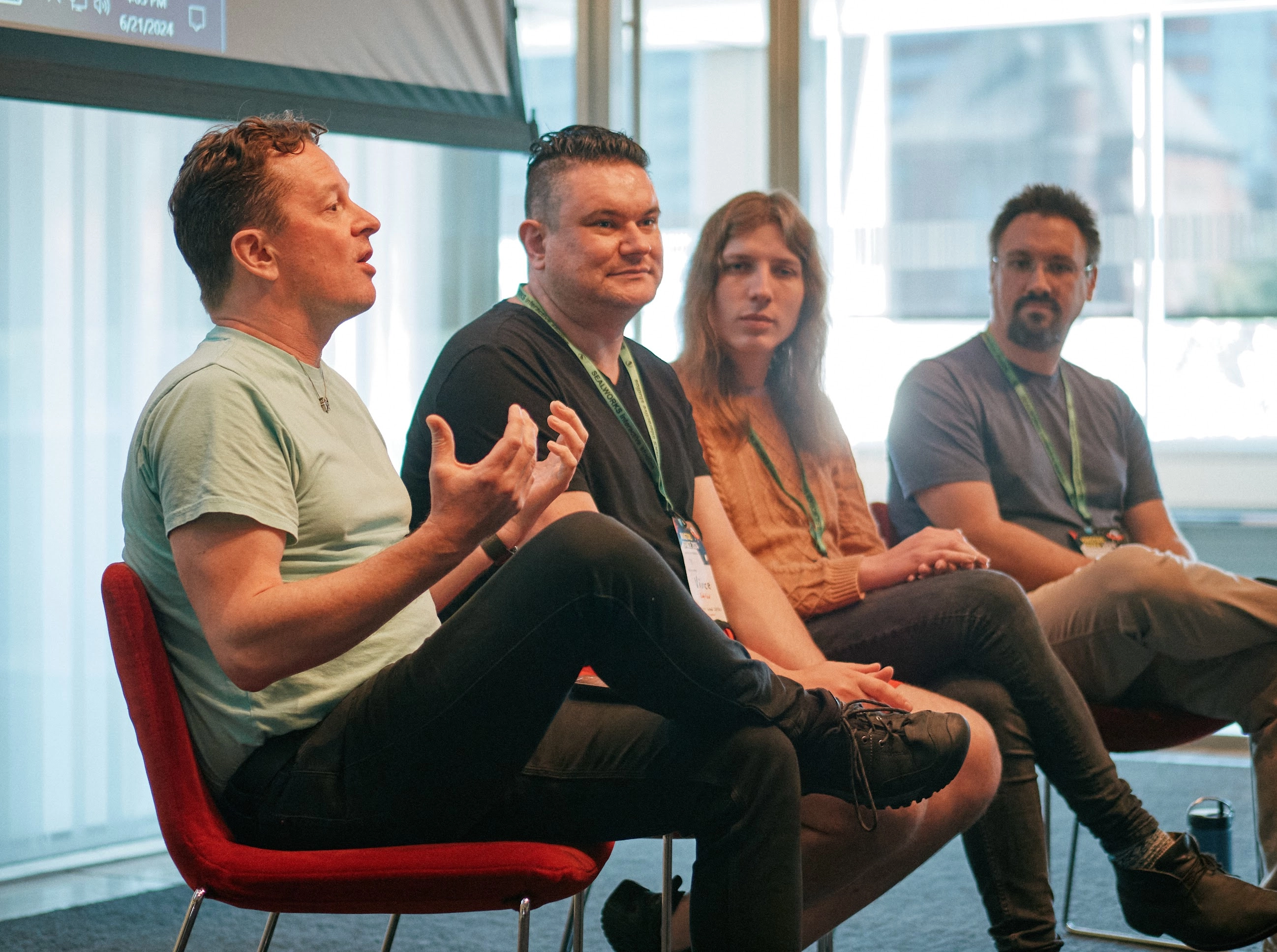 A photo of four people, the nearest one speaking